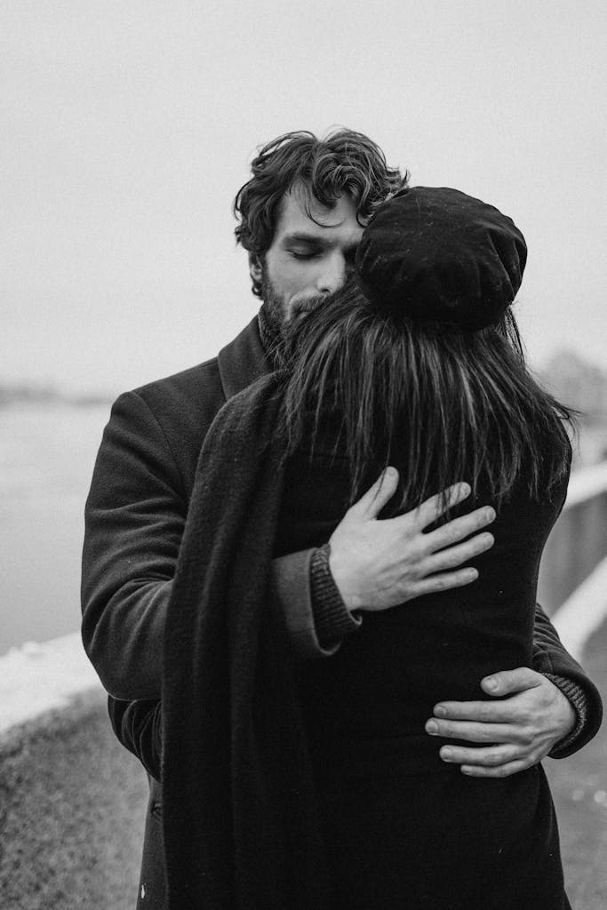 A couple shares an intimate embrace in a black and white photo, conveying love and togetherness.