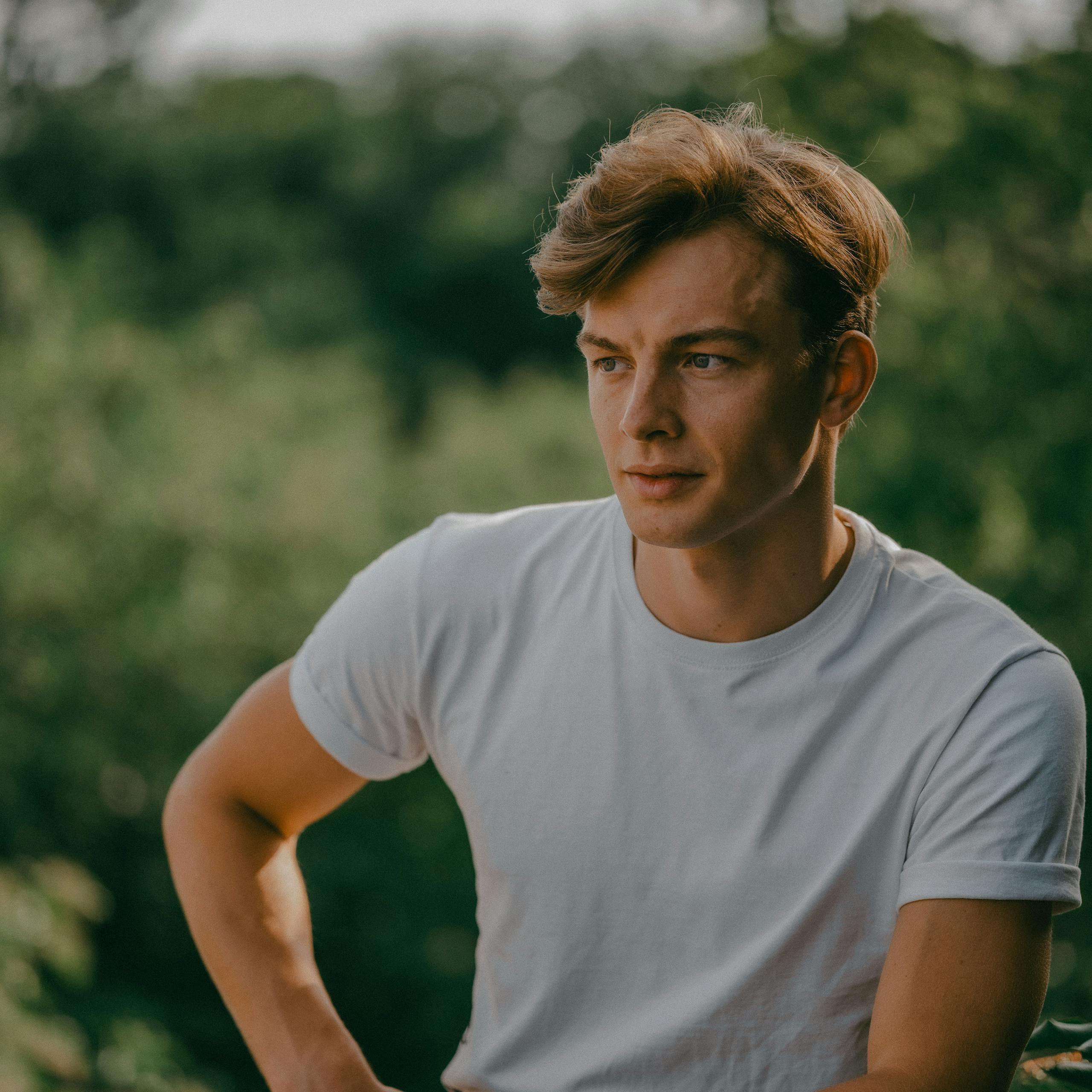 Young man in a white shirt enjoying a summer day outdoors in Berlin.